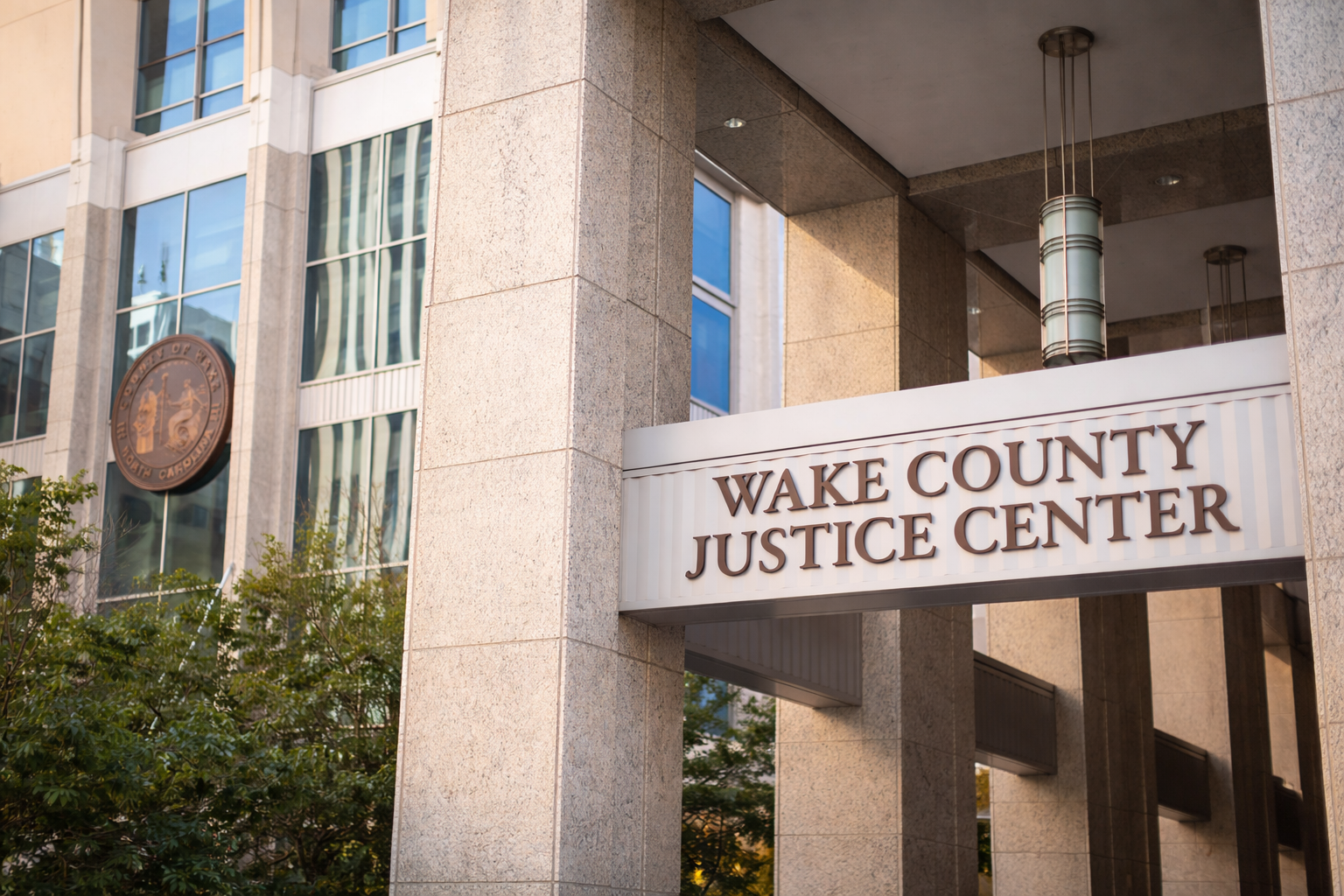 Front entrance of the Wake County Justice Center in Raleigh, North Carolina, with courthouse columns and building signage visible.